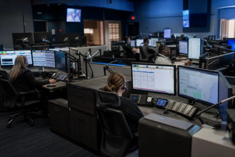 Emergency communications center with telecommunicators at multiple consoles